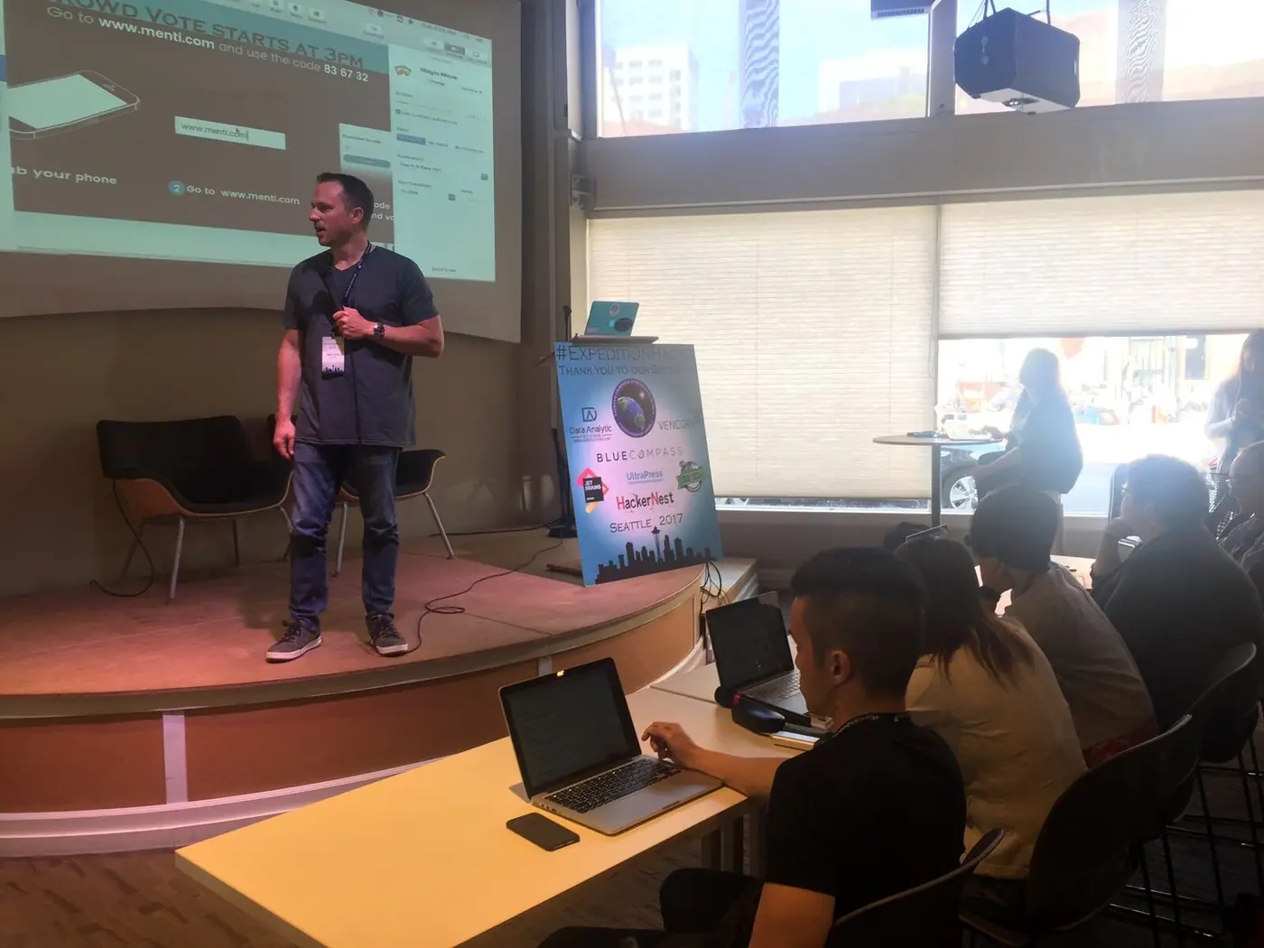 Brian Vinci presenting on stage at a startup event while guiding founders